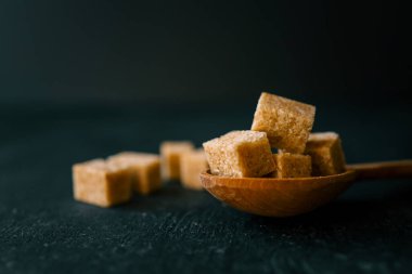 bruine suiker heap en houten lepel.