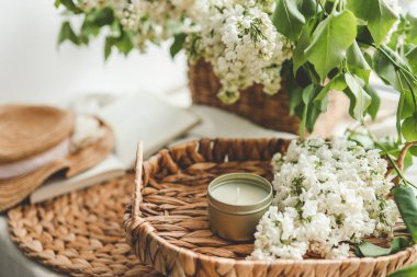 Bir tepside mum ve beyaz leylak, bahar iç mekanı..