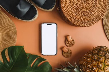 Yaz aksesuarlarının arka planında izole bir ekran olan telefon, reklam için bir yer.