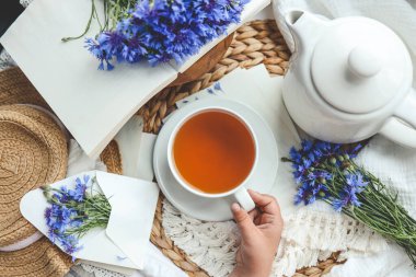 Çiçeklerin arka planında bir fincan çay, üst manzara, estetik fotoğraf..