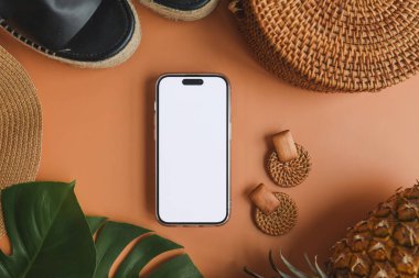 Yaz aksesuarlarının arka planında izole bir ekran olan telefon, reklam için bir yer.