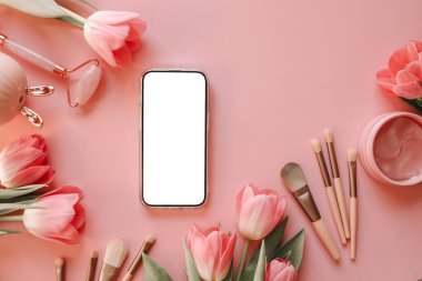 Kozmetik ürünlerinin arka planında izole ekran olan telefon.