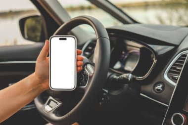 Arabadaki bir kadının ellerinde izole bir ekran olan bir telefon..