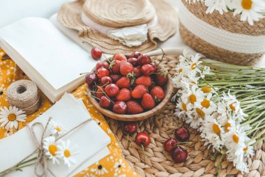 Yaz kompozisyonu, çilekli tabak ve papatya çayı..