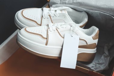 Üzerinde etiket olan şık bir çift kadın ayakkabısı, logonuz için bir yer..