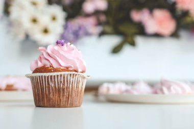 Çiçeklerin arka planında yakın plan pembe kek..