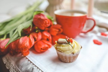 Kek, bir fincan kahve, laleler ve mumlar, bahar atmosferi..