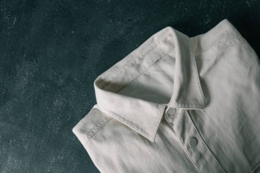 Erkek kot pantolon bej gömlek dokusunun yakın çekimi.