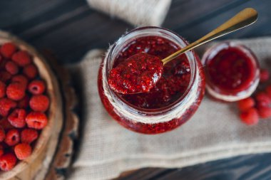 Kaşıklı kavanoz ve marifetli ahududu reçeli.