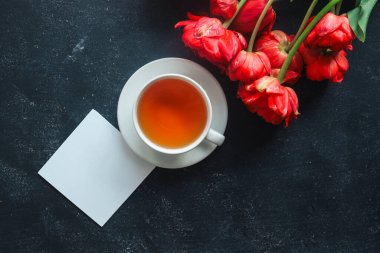 Mesajın, çayın ve bahar çiçeklerinin olduğu tebrik kartı..