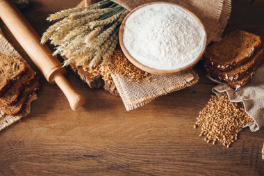 Ekmek, tahıl, buğday ve un başakları ahşap bir arka planda, fırın reklam afişi