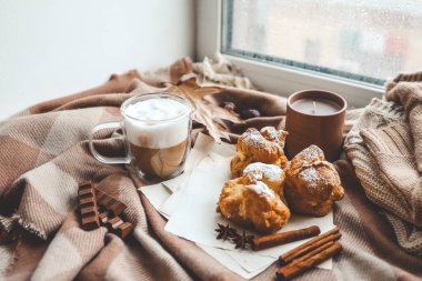 Sıcak sabah kompozisyonu, bir fincan kahve, kremalı pasta ve mum..
