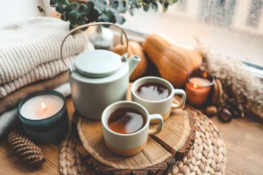 Pencere pervazına üzerinde yanan mumlar ve çay ile güzel sonbahar kompozisyon.