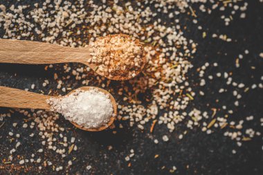 Siyah arka planda farklı baharatlı ahşap kaşıklar, afiş..