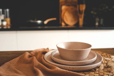 Mutfağın arka planındaki masada bej rengi minimalist tabaklar..