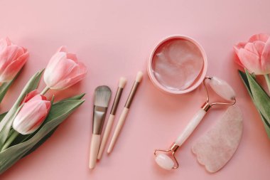 Üst görünüm kozmetik seti, makyaj fırçaları, göz bantları, yüz silindiri.