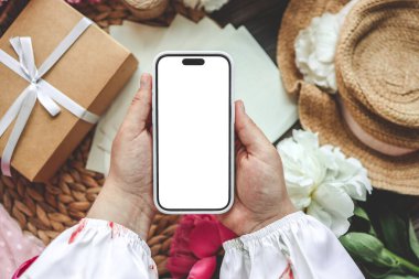 Neşeli bir arka planda cep telefonu ve bahar çiçekli şakayıklar. Aşk teması, Anneler Günü, Kadınlar Günü düzlük.