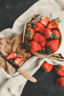 Tahta kasede çilek. Tahta masada taze çilekler var. Günaydın ve kahvaltı konsepti.