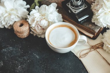 Yaz kompozisyonu üst görünümü. Bir fincan kahve, şakayık ve retro kamera, duvar kağıdı, metin için yer.