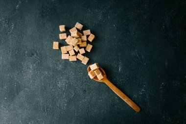 bruine suiker heap en houten lepel.