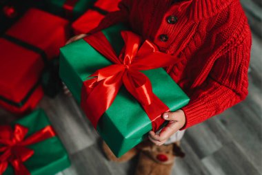 Elinde hediye kutusu olan küçük bir çocuk. Yeni yıl atmosferi..