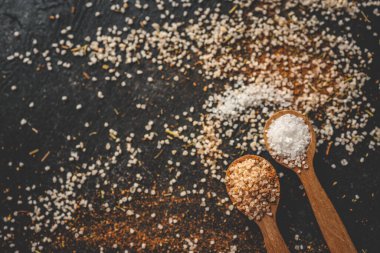 Siyah arka planda farklı baharatlı ahşap kaşıklar, afiş..