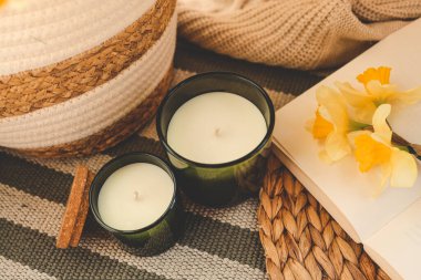 İki mum ve içinde nergis olan bir sepet..