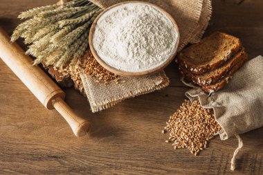 Ekmek, tahıl, buğday ve un başakları ahşap bir arka planda, fırın reklam afişi