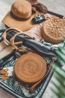 Tahta arka planda seyahat çantası, şapka ve güneş gözlüklerini kapatın..