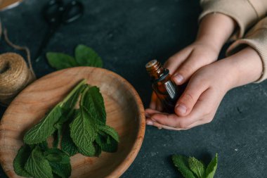 Ahşap zemin üzerinde nane olan bir şişe gerekli yağ..