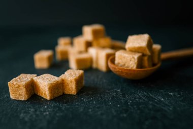 bruine suiker heap en houten lepel.