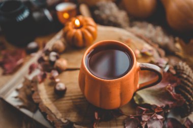 Sonbahar süsü, bir fincan çay, mumlar, balkabakları..