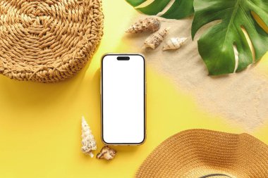 Yaz aksesuarlarının arka planında izole bir ekran olan telefon, reklam için bir yer.