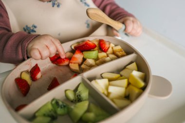 Bebek kendi kendini besleme yöntemini kullanarak besin yiyor., .