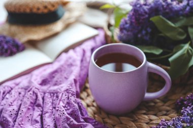 Bir fincan sıcak çay ve leylak çiçeği, günaydın konsepti..