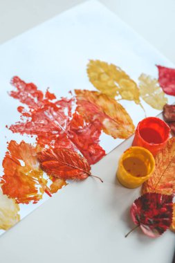 Children's autumn activity, leaf print on paper. clipart