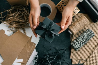 Paketleme malzemeleri ve hediyeler için arkaplanda fiyonklu bir hediye kutusu..
