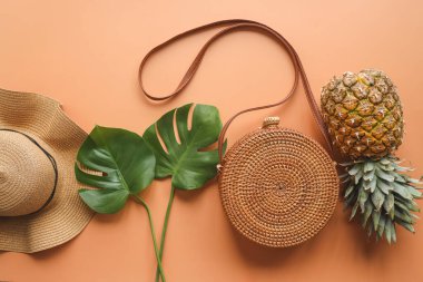 Renkli yaz kadın moda kıyafeti düz-düz. Hasır şapka, bambu çanta, palmiye dalları, bej arka planda ananas, üst manzara, geniş kompozisyon. Yaz modası, tatil konsepti.