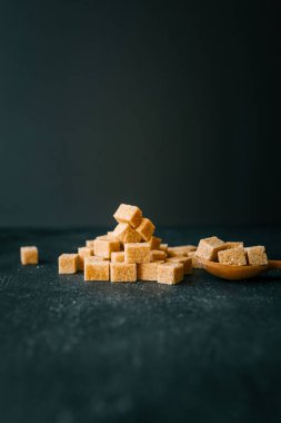 Siyah arkaplanda kamış şekeri küpleri.