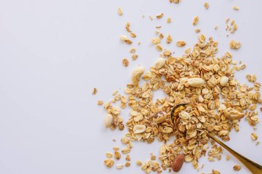 Beyaz arka planda izole kaşık üzerinde Granola, kopya alanı. Sağlıklı atıştırmalık veya kahvaltı konsepti - tahıl ve fındık ile ev yapımı granola.