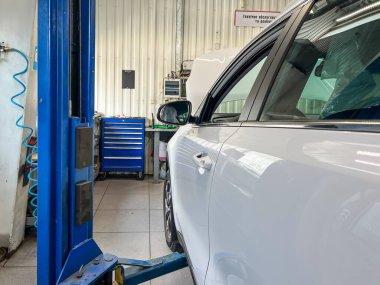 Benzin istasyonunda asansördeki beyaz araba..