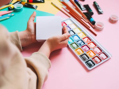 Okula dönelim. Panoramik eğitim afişi. Üst manzara, düz yatış. Masada renkli malzemeler, renkli kağıtlar. Çocukların yaratıcılık kavramı. Anaokulu eğitimi, gelişme. Okul için aksesuarlar..