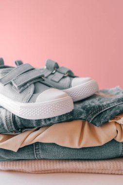 Bebek ayakkabılı bebek kıyafetleri yığını. Reklamcılık, tarz ve moda.