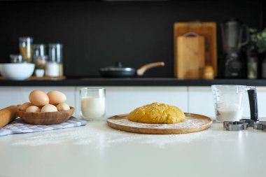 Ahşap masaya konmuş, pişirmeye hazır yemek malzemeleri. Metin için kopyalanma alanı. Yemek hazırlama kavramı, arka planda mutfak..