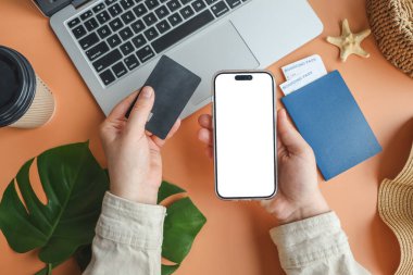 Kredi kartı ve akıllı telefon tutan kadın online uçak bileti satın alma, üst görünümü