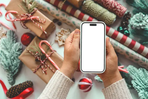 Noel hediyelerinin arka planında izole edilmiş ekranlı telefon.