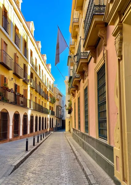 Narrow cobblestone alley and architecture in a neighborhood of Seville, Spain.