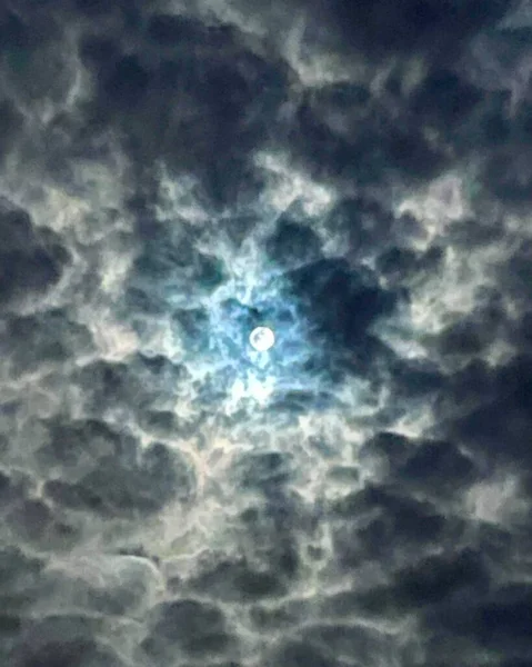 月光在乌云后面闪耀 在越来越多的暴风雨云后面 可以看到满月 发出蓝色的光芒 乌云后面的蓝色光芒给人一种不祥而可怕的感觉 — 图库照片