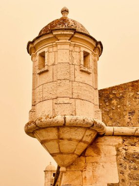 Bir kum fırtınası sırasında görülen antik bir kalenin kulesi gökyüzünün altın renginde görünmesine neden oluyor.