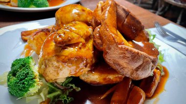 Tavuk, sebze, sos ve Yorkshire Pudingi ile nefis bir pazar rostosu.